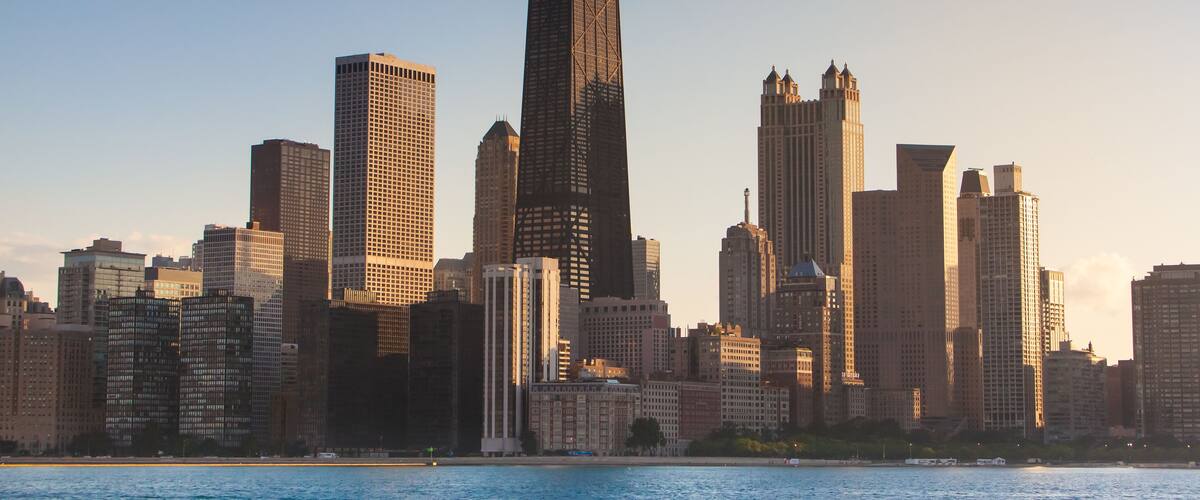 A city skyline with a prominent skyscraper and several other high-rise buildings.