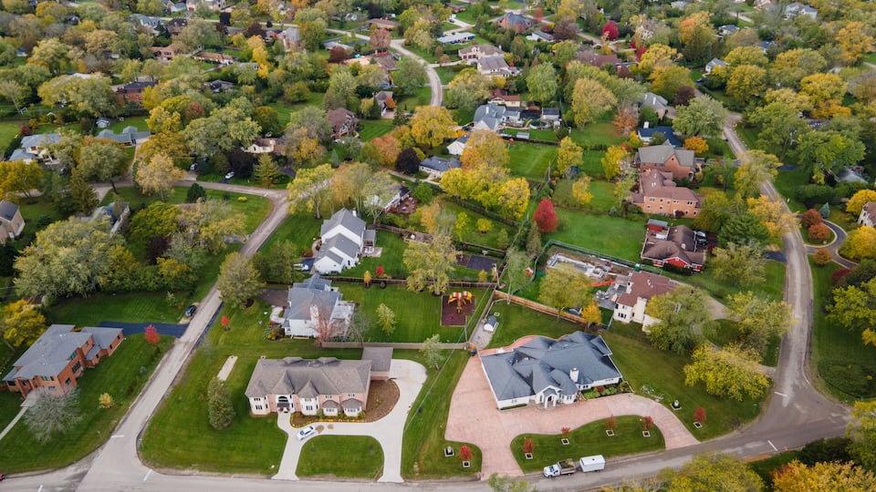 An aerial view of a residential neighborhood with houses, roads, and trees.