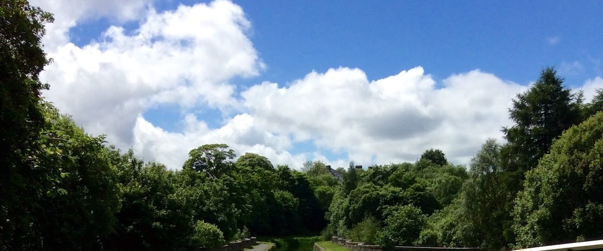 A canal with a curved pathway and a stone bridge.