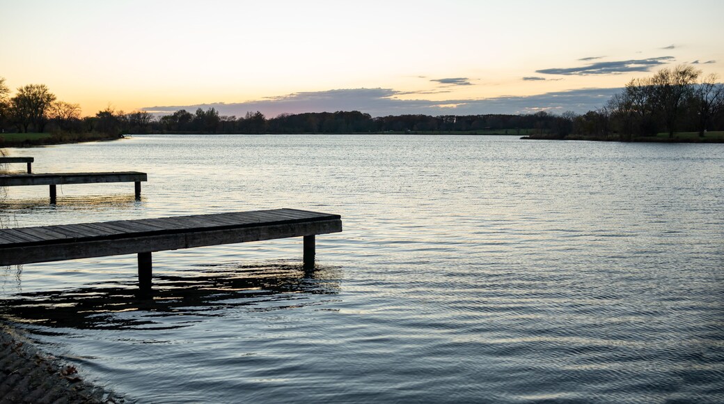 A calm lake with a wooden dock extending into the water.