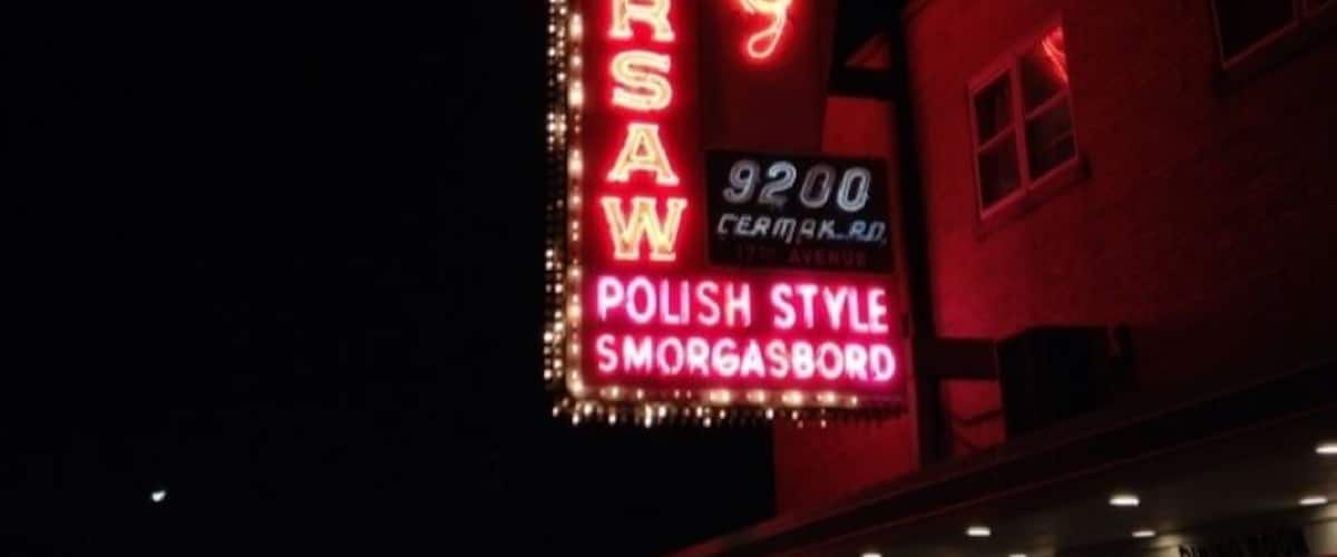 A neon sign for Old Warsaw Polish Style Smorgasbord.