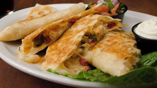 The Grilled Chicken Quesadilla from The Irish Legend Pub and #Restaurant, made with roasted chicken, chiuahua cheese, onions, and red bell pepper, served with a side of sour cream.