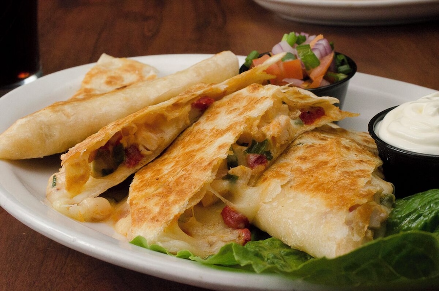 The Grilled Chicken Quesadilla from The Irish Legend Pub and #Restaurant, made with roasted chicken, chiuahua cheese, onions, and red bell pepper, served with a side of sour cream.