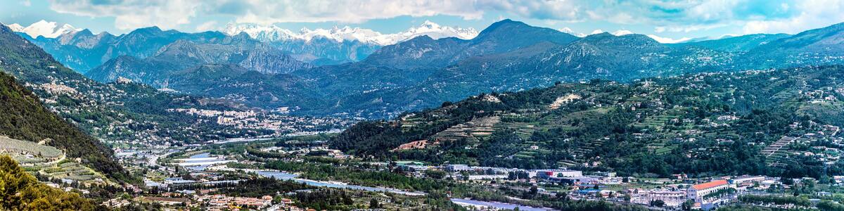 Panoramic view of Var Valley from Saint Laurent du Var village, the suburb of Nice city. Mountains of Mercantour National Park isa at background. French Riviera.
