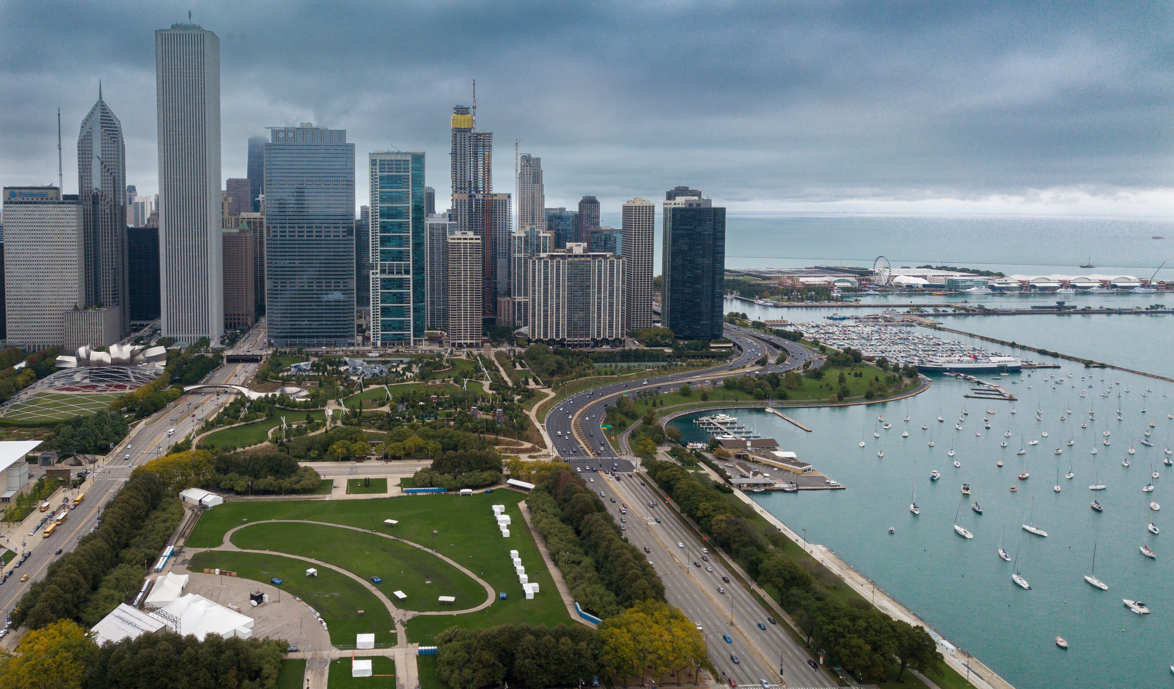 View of Downtown Chicago buildings looking north over Grant Park with Lake Michigan and Lake Shore Drive on right side. Prudential Building and Standard Oil Buildings on left side.