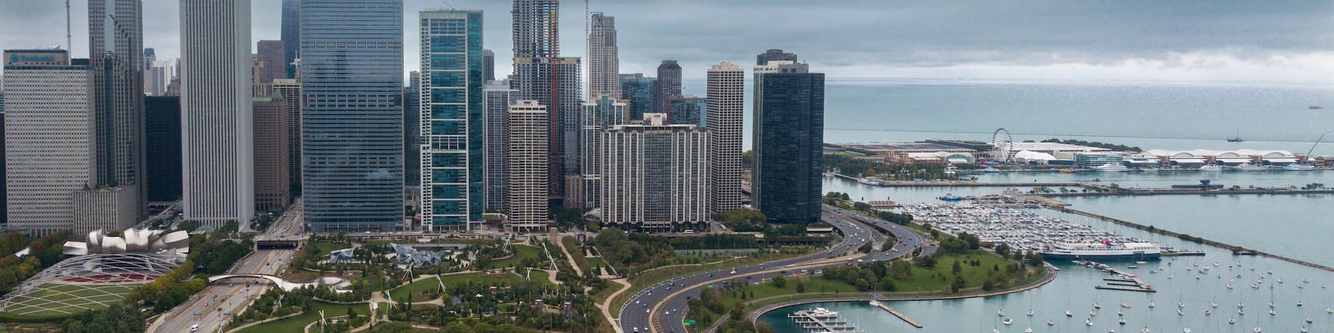 View of Downtown Chicago buildings looking north over Grant Park with Lake Michigan and Lake Shore Drive on right side. Prudential Building and Standard Oil Buildings on left side.