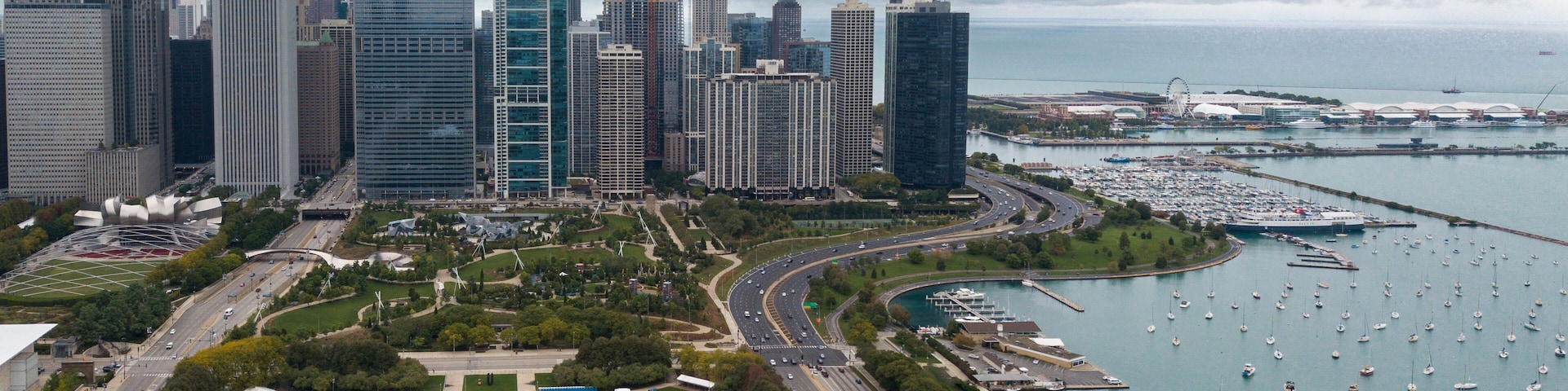 View of Downtown Chicago buildings looking north over Grant Park with Lake Michigan and Lake Shore Drive on right side. Prudential Building and Standard Oil Buildings on left side.