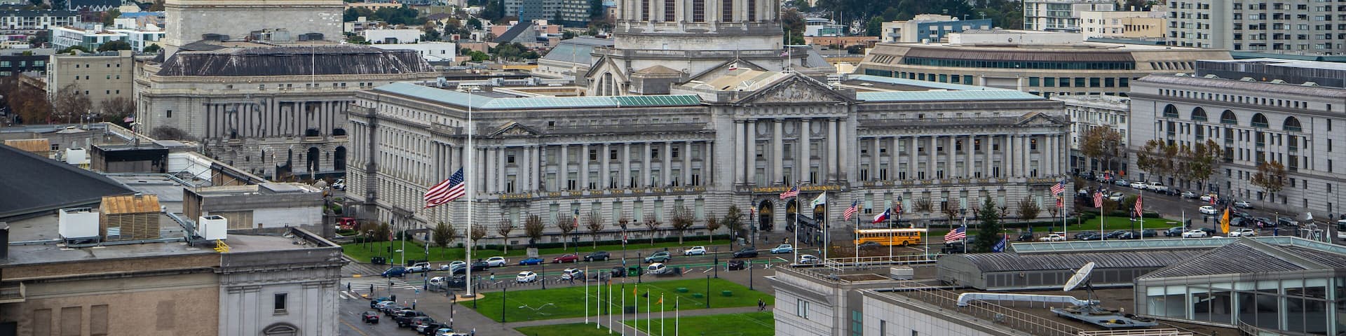 A large government building with a prominent dome and a flag in front.