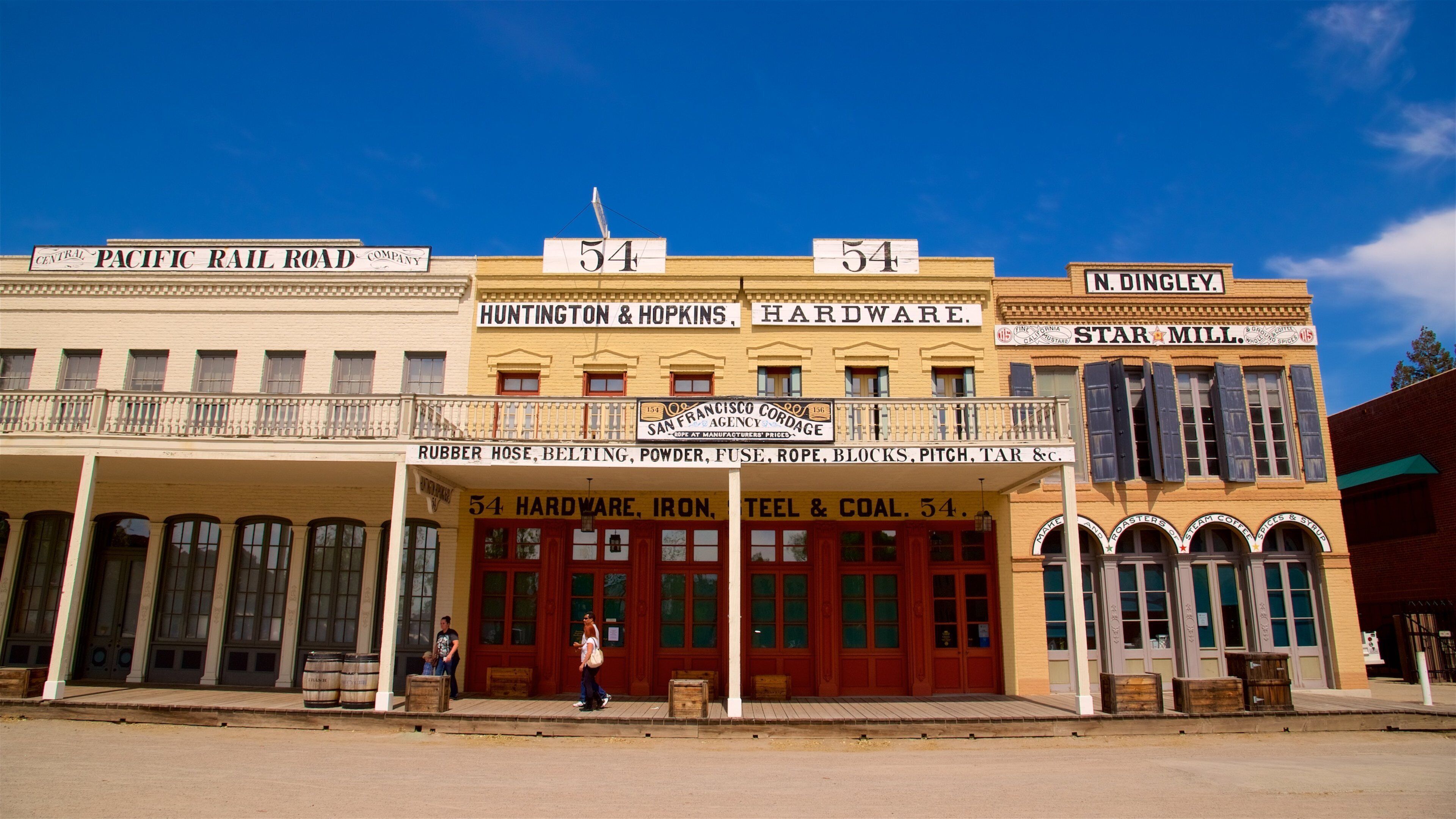 A row of historic buildings with signs for Central Pacific Rail Road Company, Huntington & Hopkins Hardware, and Star Mill.