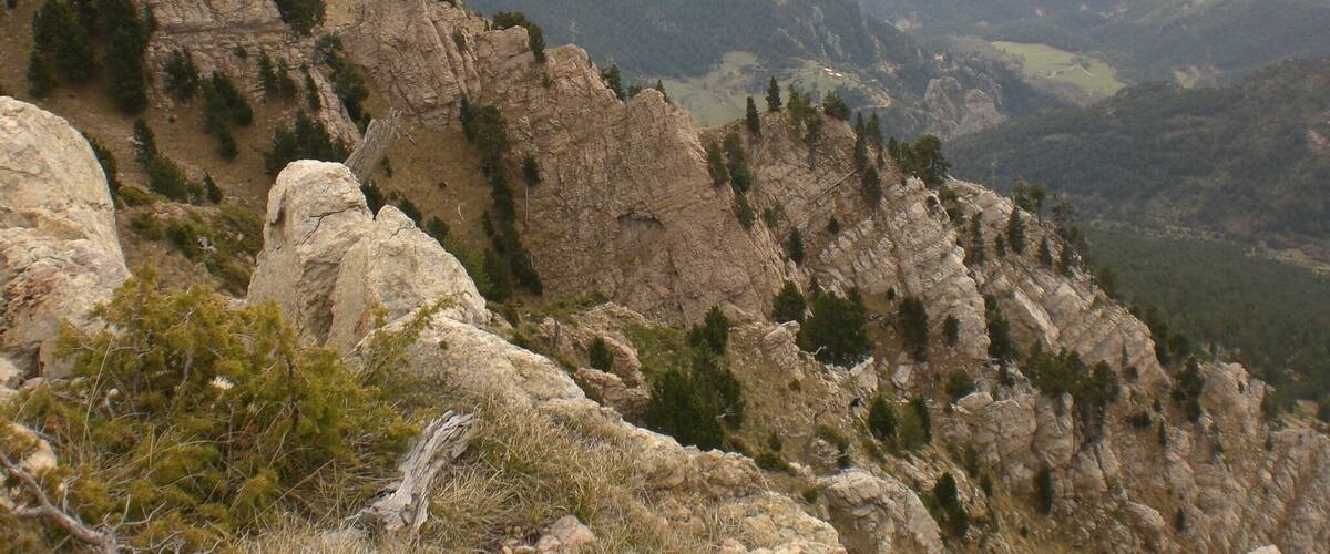 A rugged mountain landscape with rocky outcrops and sparse vegetation.