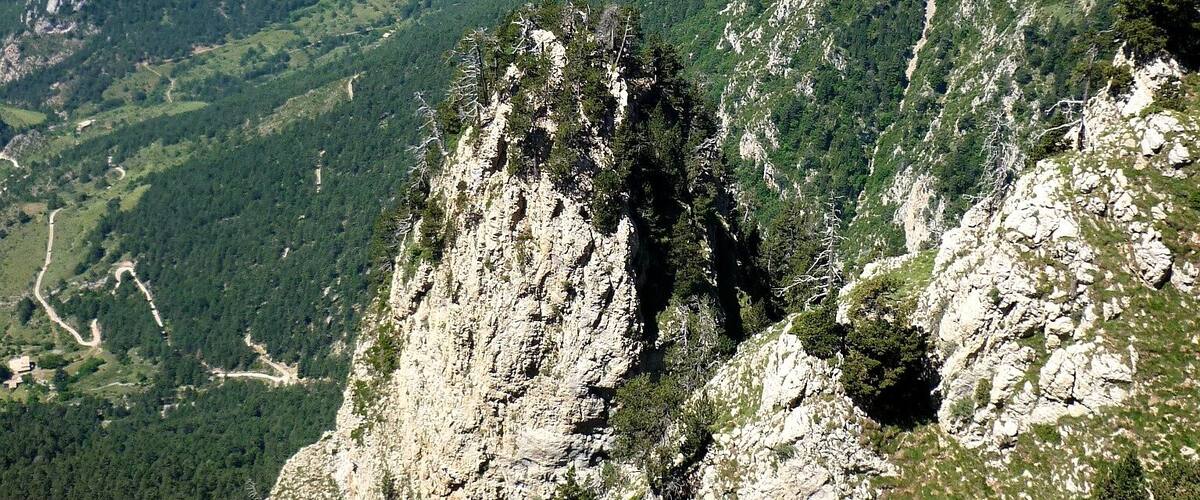 A mountainous landscape with rocky outcrops and dense forests.