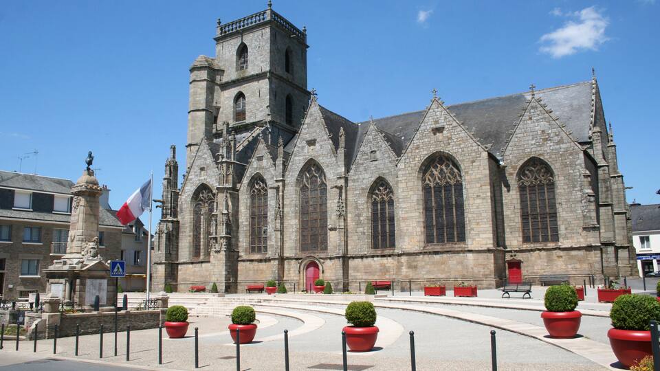 A historic church with a tall bell tower and large arched windows.