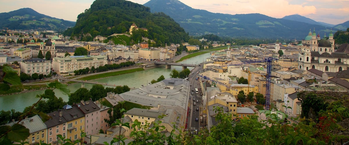 A cityscape with a river, historic buildings, and a mountain in the background.
