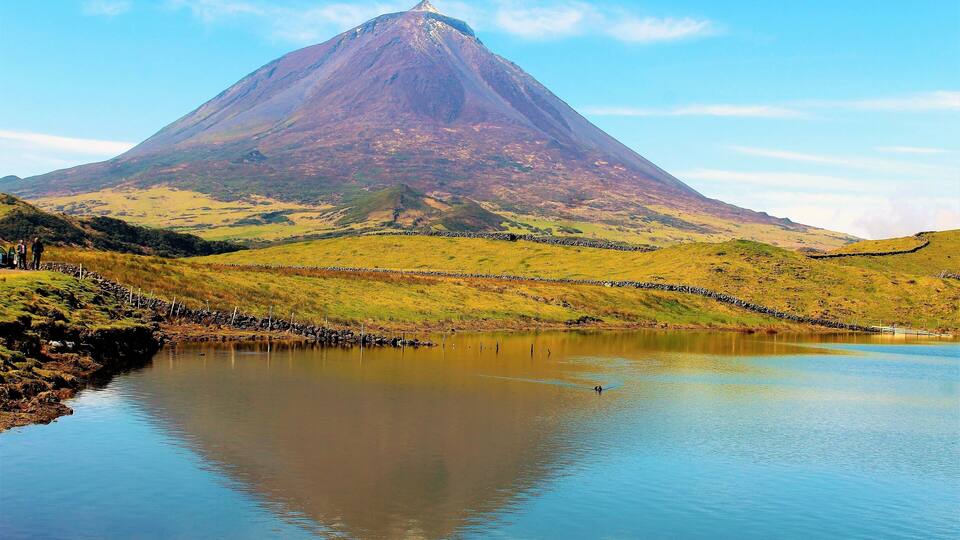 A mountain with a lake in the foreground.