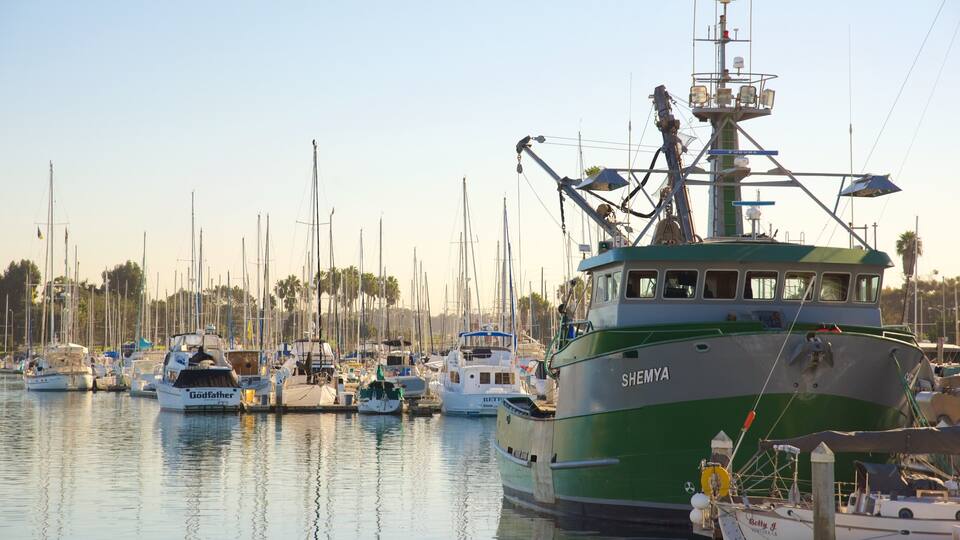 Un puerto deportivo con varias embarcaciones amarradas, incluyendo un barco grande verde y blanco llamado SHEMYA.