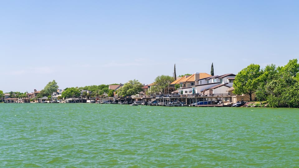 A waterfront town with houses and boats along the shore.