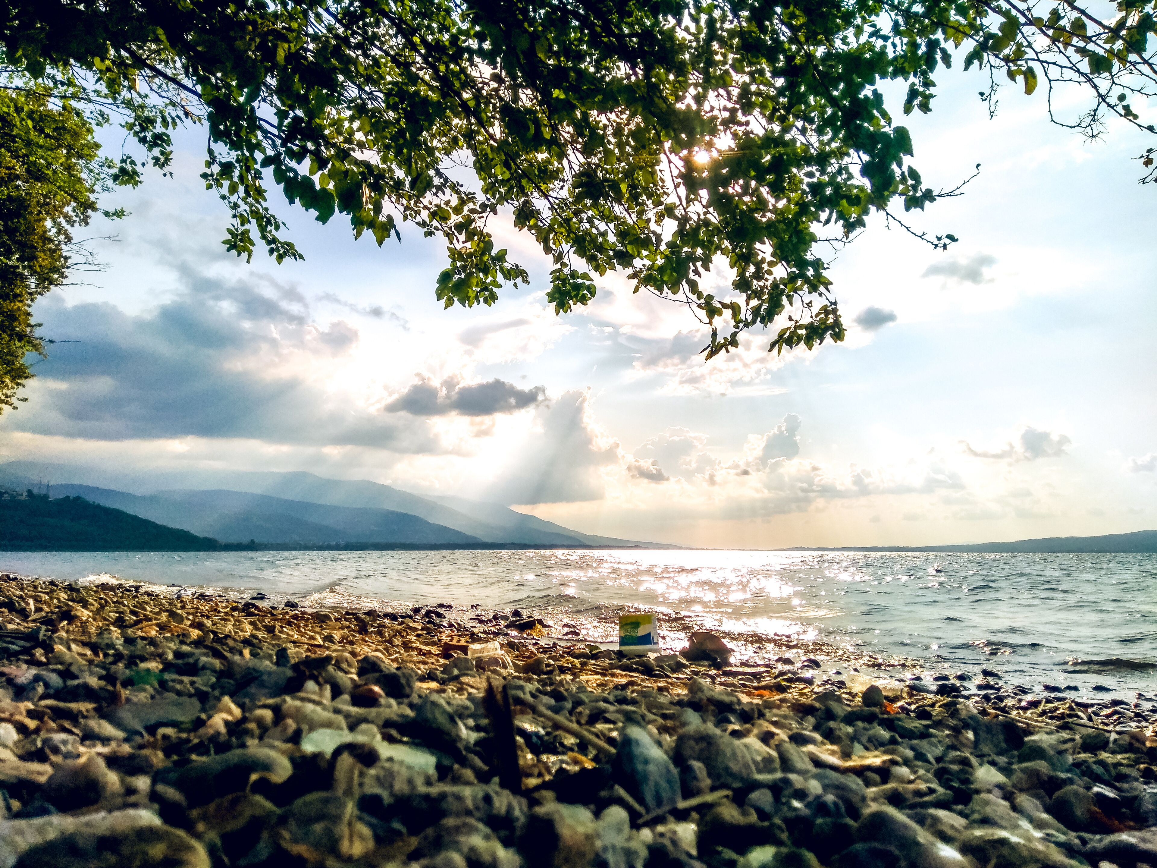 A wavy lakeside view of Sapanca Lake with dramatic light and sky.