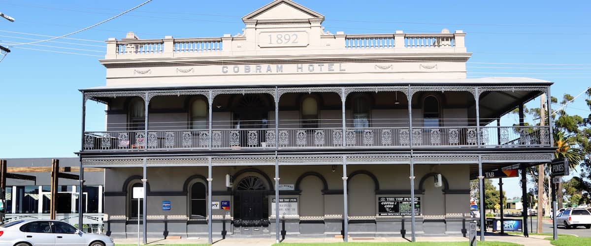 A historic building labeled "Cobra Hotel" with a balcony and a year "1892" on the facade.