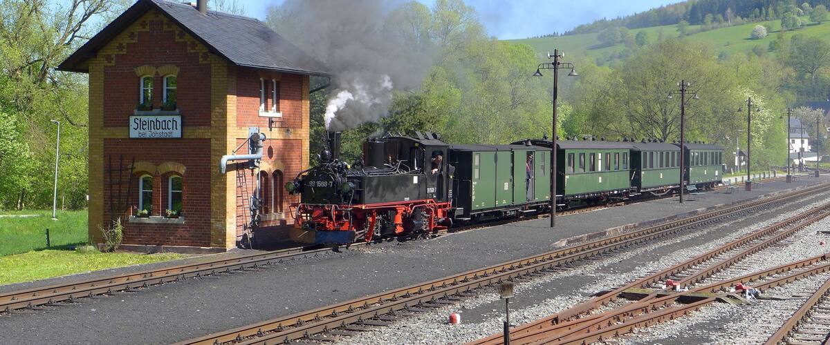 A steam locomotive at a train station with a building labeled "Sleibach".
