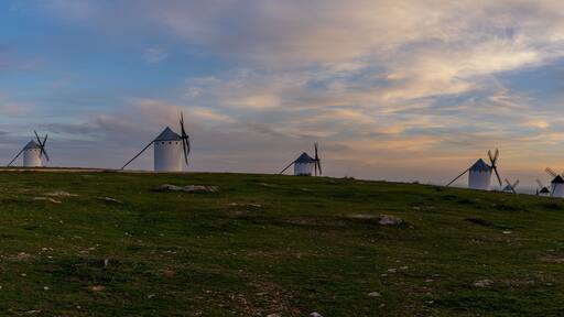panorama view of the historic white windmills of La Mancha above the town of Campo de Criptana at sunset