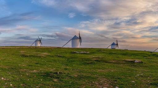 panorama view of the historic white windmills of La Mancha above the town of Campo de Criptana at sunset