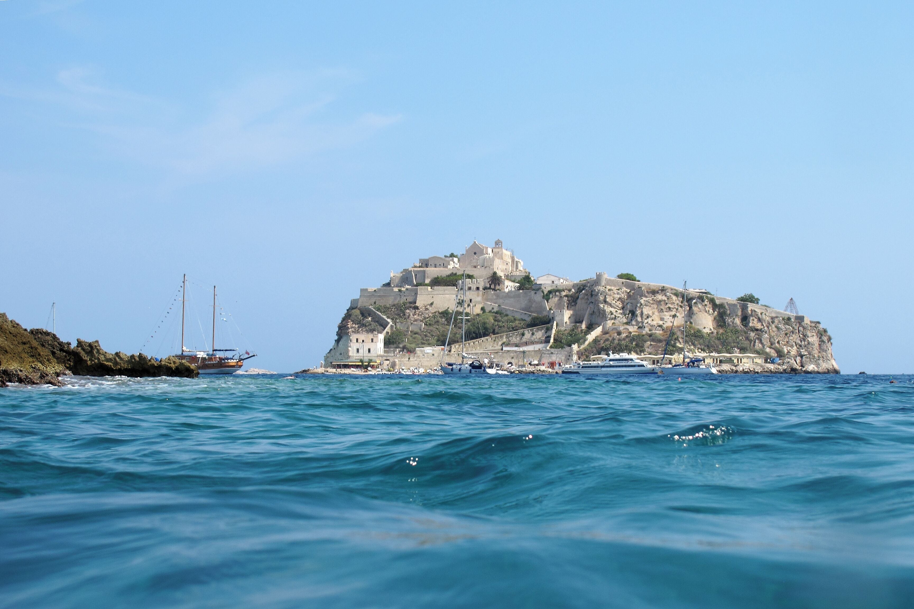 A coastal town with a prominent castle on a cliff overlooking the sea.