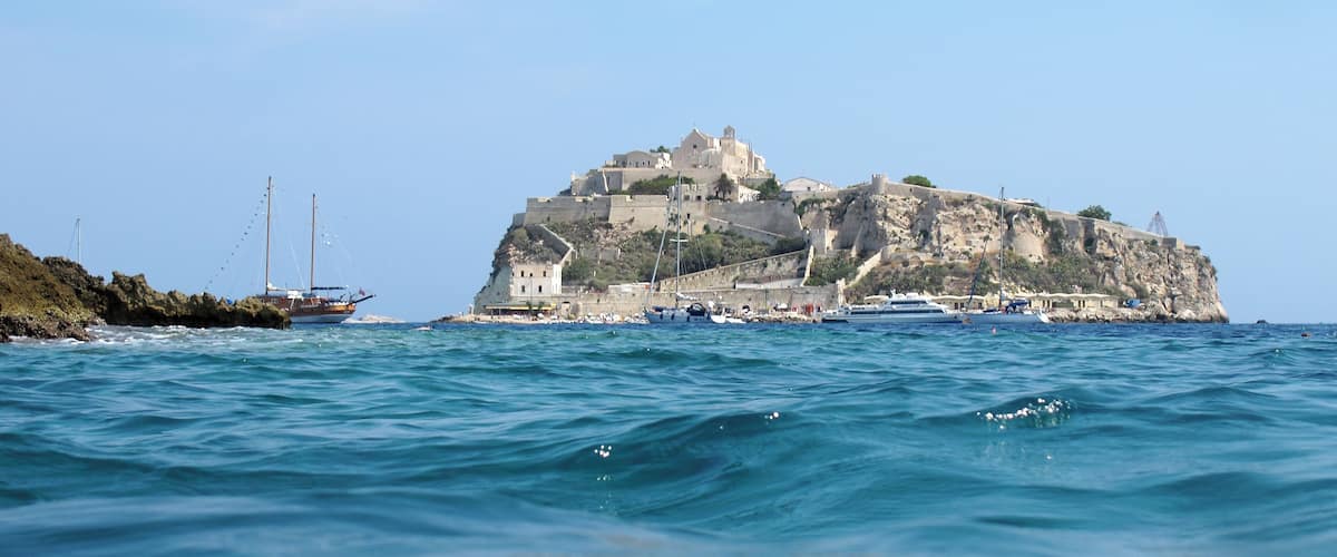 A coastal town with a prominent castle on a cliff overlooking the sea.