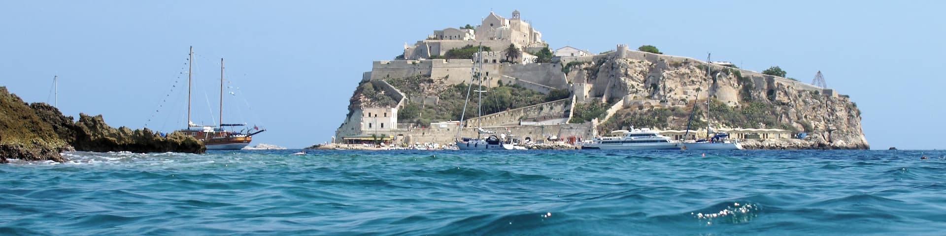A coastal town with a prominent castle on a cliff overlooking the sea.