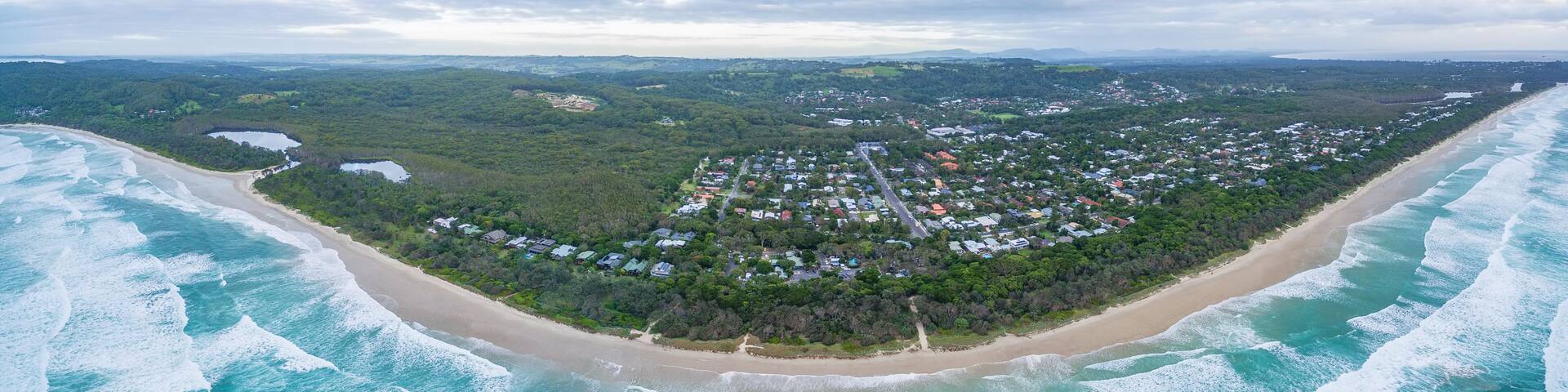 Wide aerial panorama of ocean coastline and Suffolk Park suburb in NSW, Australia