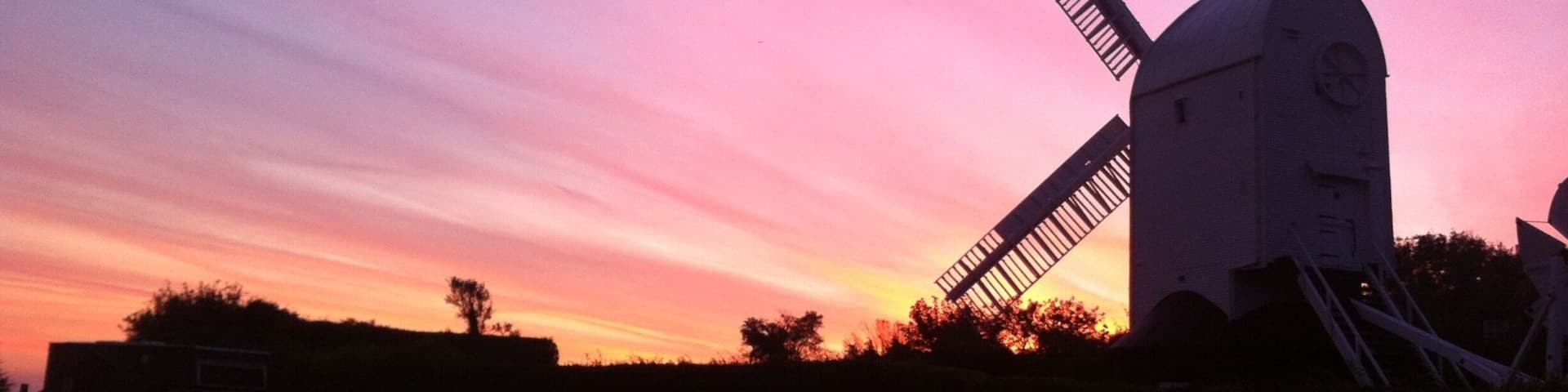 A windmill silhouetted against a sunset sky.
