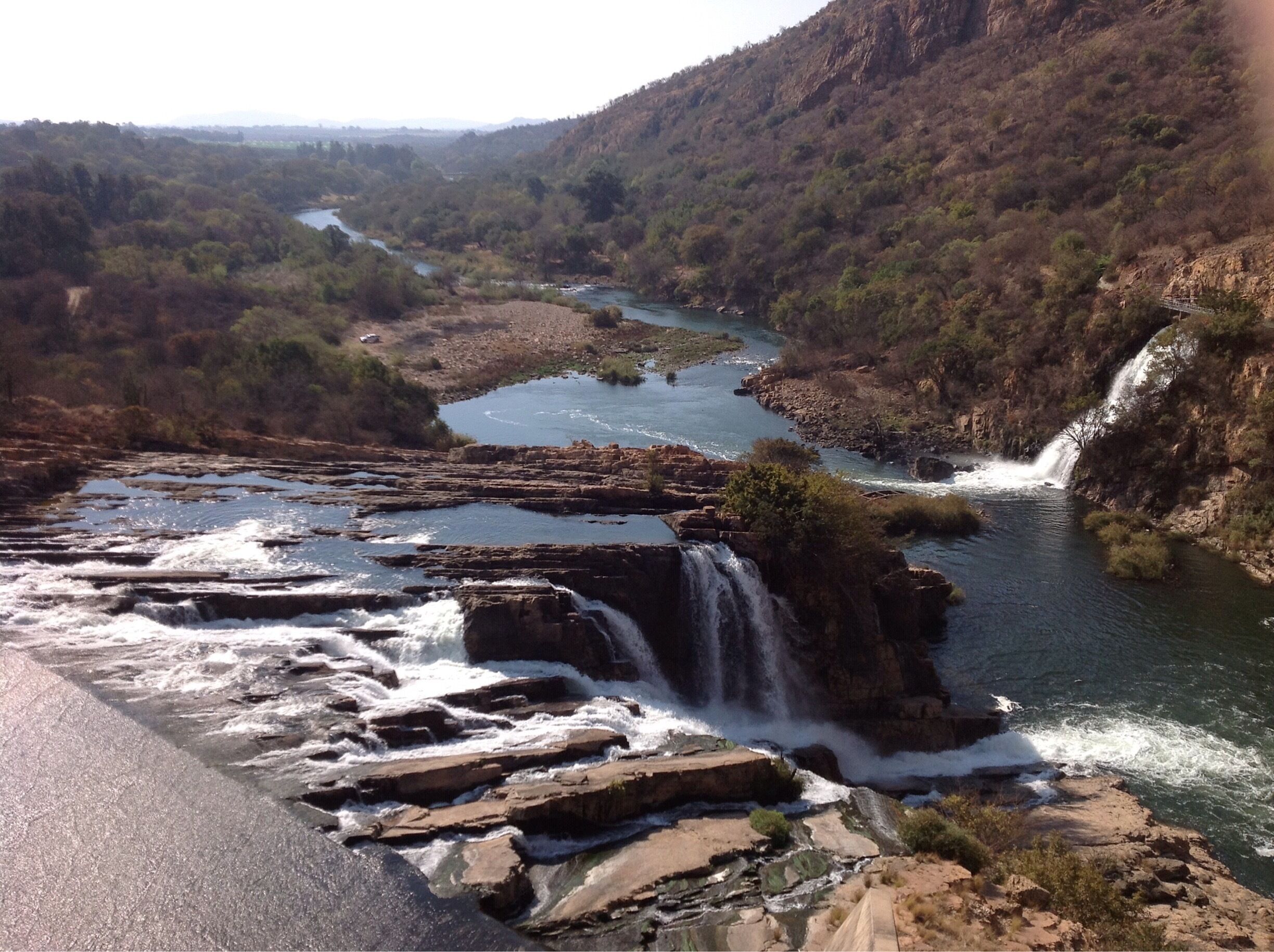 A river flowing through a mountainous landscape with multiple waterfalls.