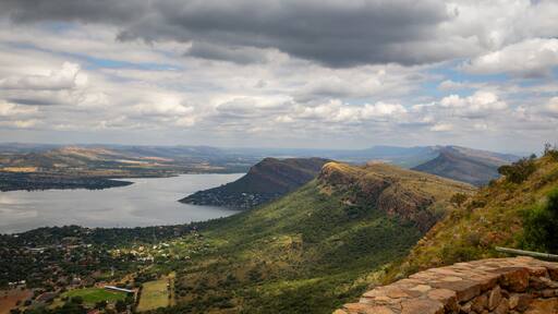 Cuestas, landforms of tilted rock layers or strata, on the north shore of Hartbeespoort dam under a cloudy sky in the Magaliesberg mountain range in North West province in South Africa.