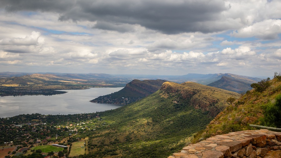 Cuestas, landforms of tilted rock layers or strata, on the north shore of Hartbeespoort dam under a cloudy sky in the Magaliesberg mountain range in North West province in South Africa.