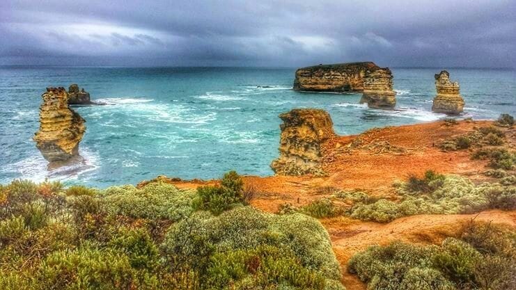 A coastal landscape with prominent rock formations and a rugged terrain.