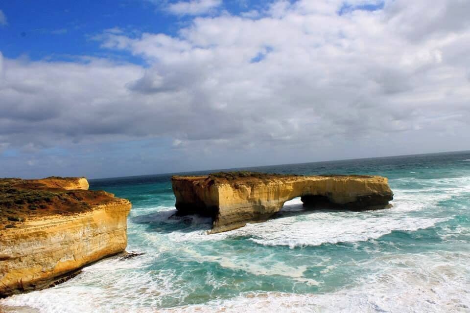 A coastal landscape with large rock formations and the ocean.