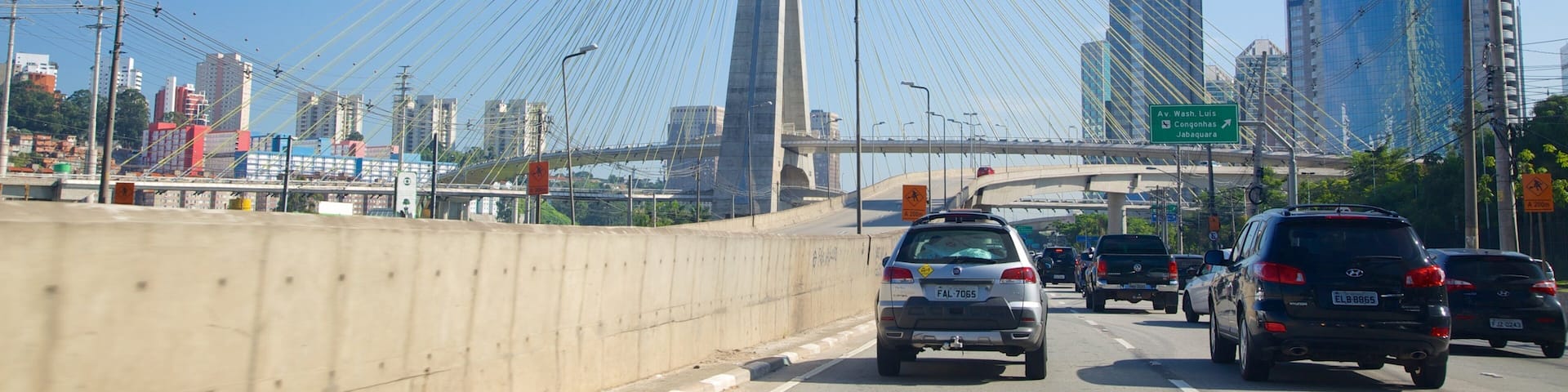 A busy highway with a cable-stayed bridge in the background.