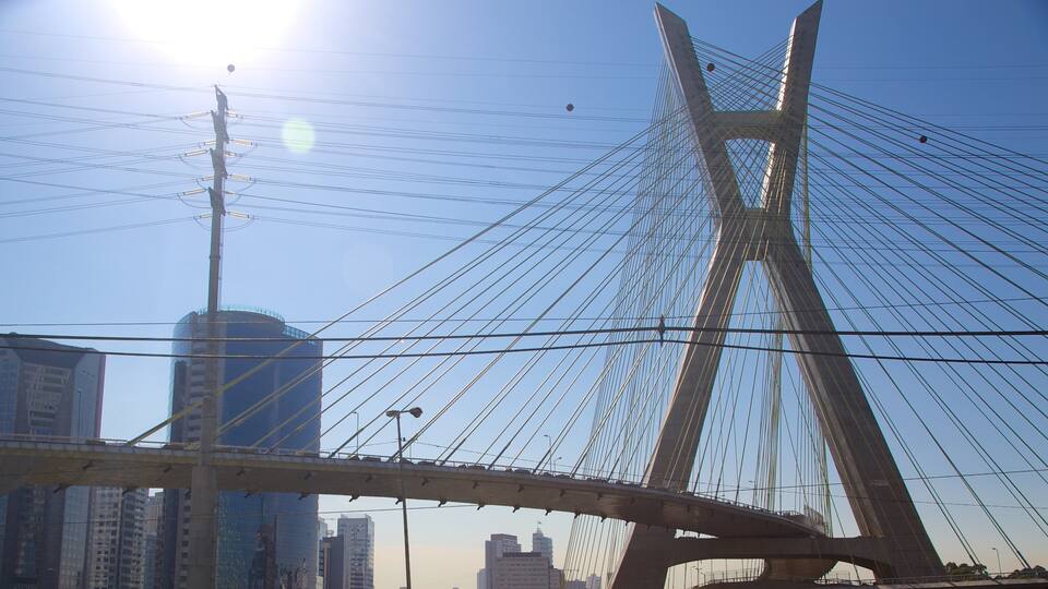 A cable-stayed bridge with a clear sky and city buildings in the background.