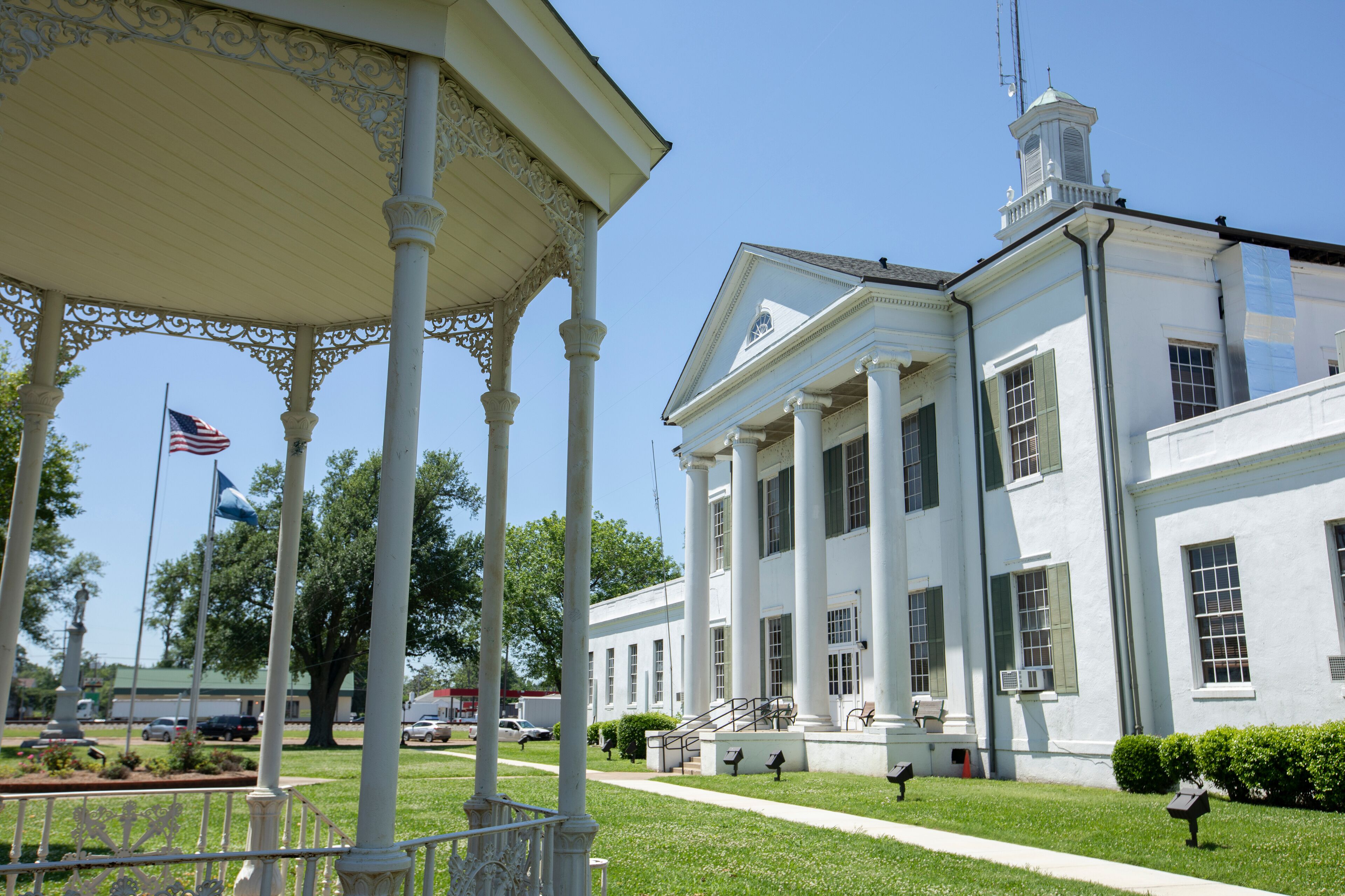A white building with columns and a flagpole.