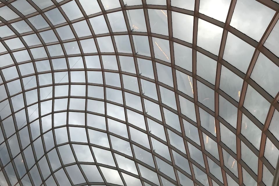 A large, curved glass ceiling with a grid pattern.