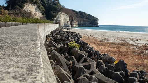Tetrapods and Seawall at Iwama Beach, Iwaki City, Fukushima Prefecture, Japan, on a Clear Winter Day. Coastal defense structures with rocky shoreline and blue ocean under sunny sky – ideal for travel,