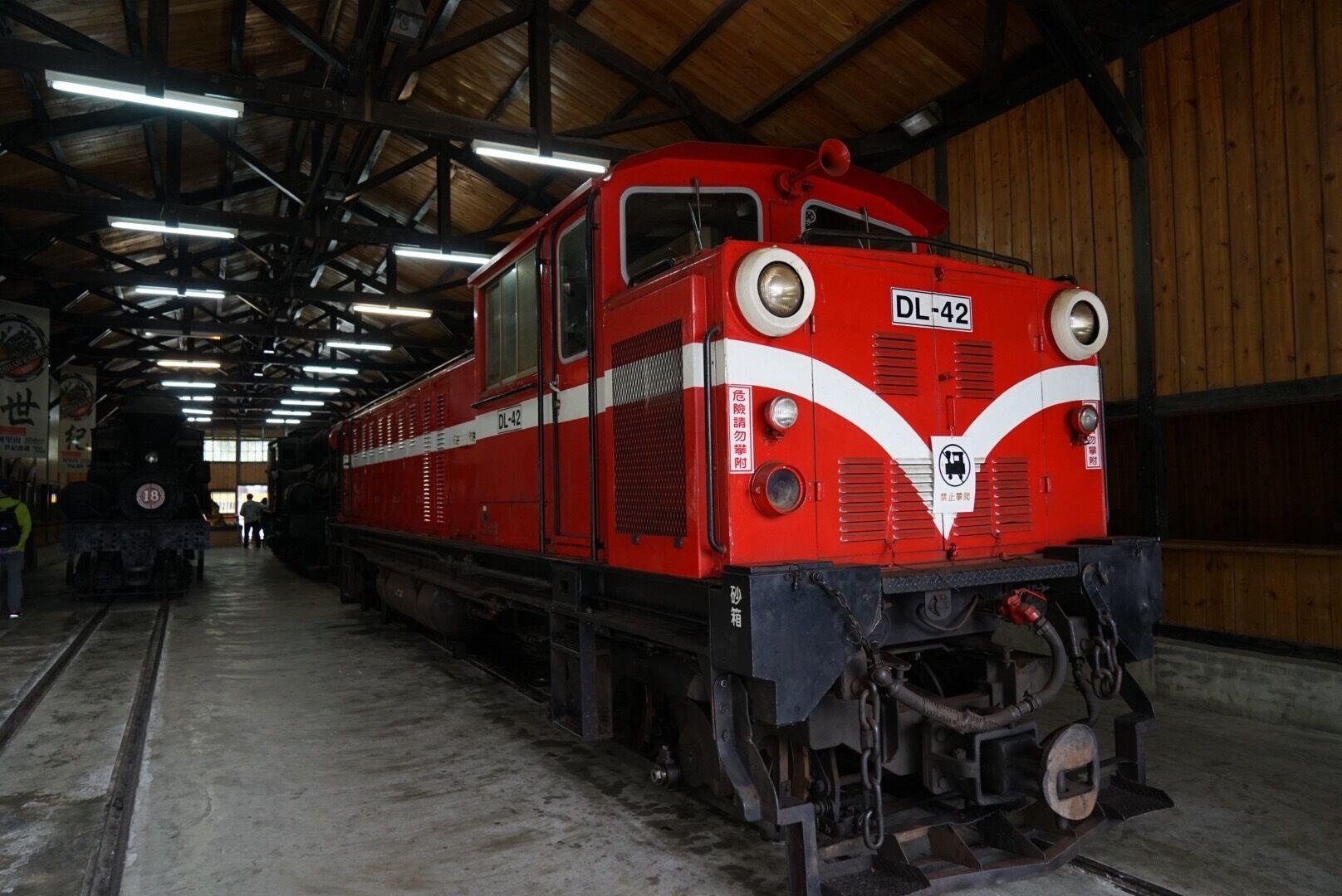 A red train with the number DL-42 parked inside a covered facility.
