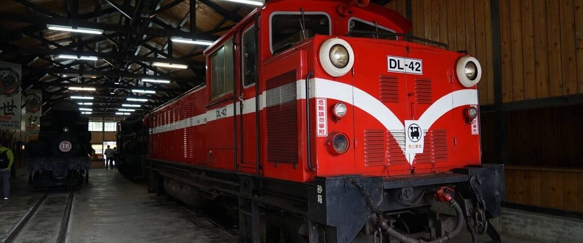 A red train with the number DL-42 parked inside a covered facility.