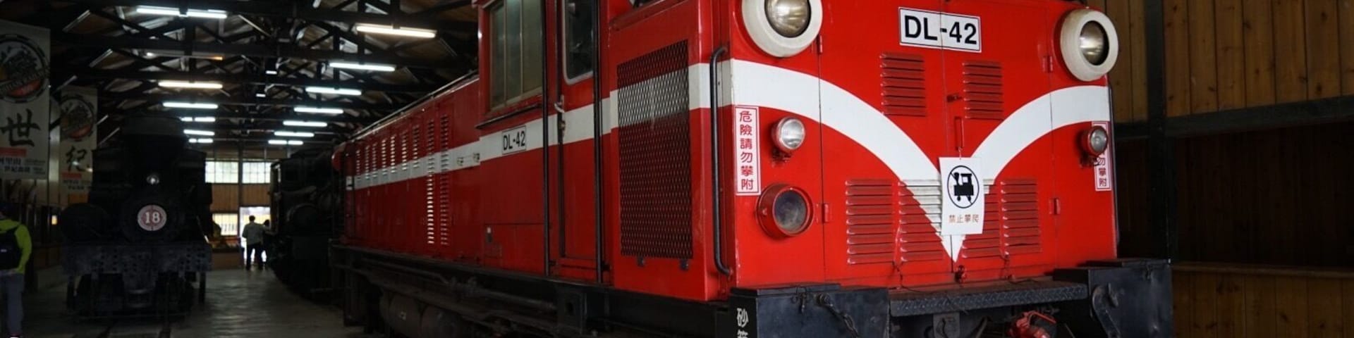 A red train with the number DL-42 parked inside a covered facility.