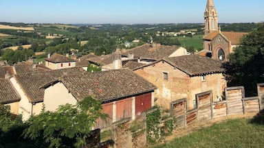 A village with traditional buildings and a church with a tall tower.