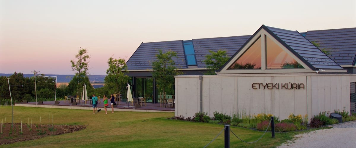 Un bâtiment sur lequel est apposée une enseigne indiquant « ETYEKI KÜRIA », situé dans un espace aménagé avec de la pelouse et des arbres.