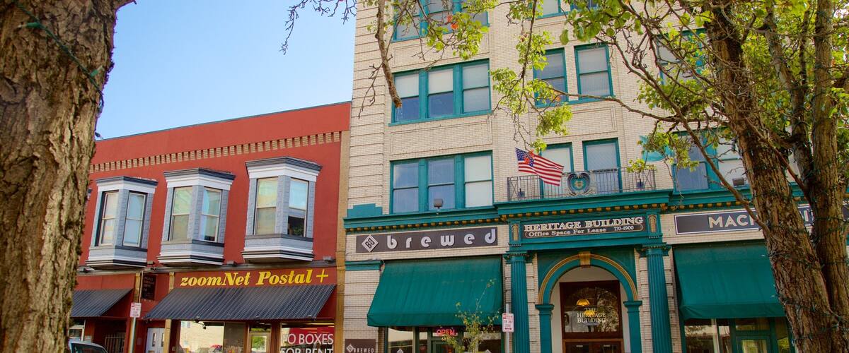 A street with buildings, including a red building with a 'zoomNet Postal' sign and a green building with a 'Heritage Building' sign.