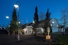 Le musée de l'aviation Pearson au crépuscule, avec des lampadaires illuminés et une statue au premier plan.