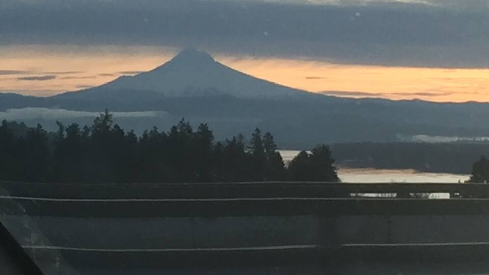 A mountain at sunset with a bridge in the foreground.