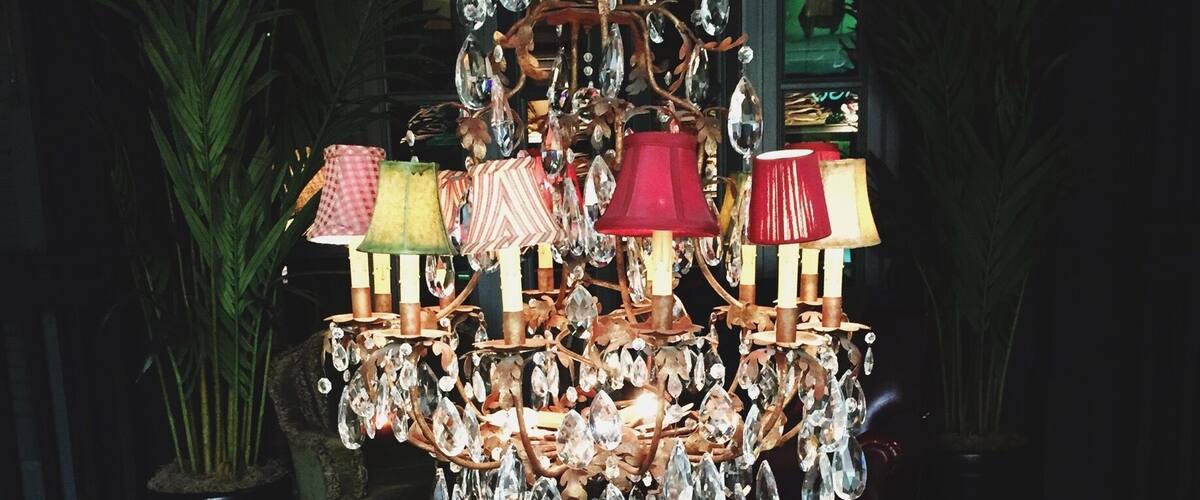 A wooden coffee table with a chandelier above it.