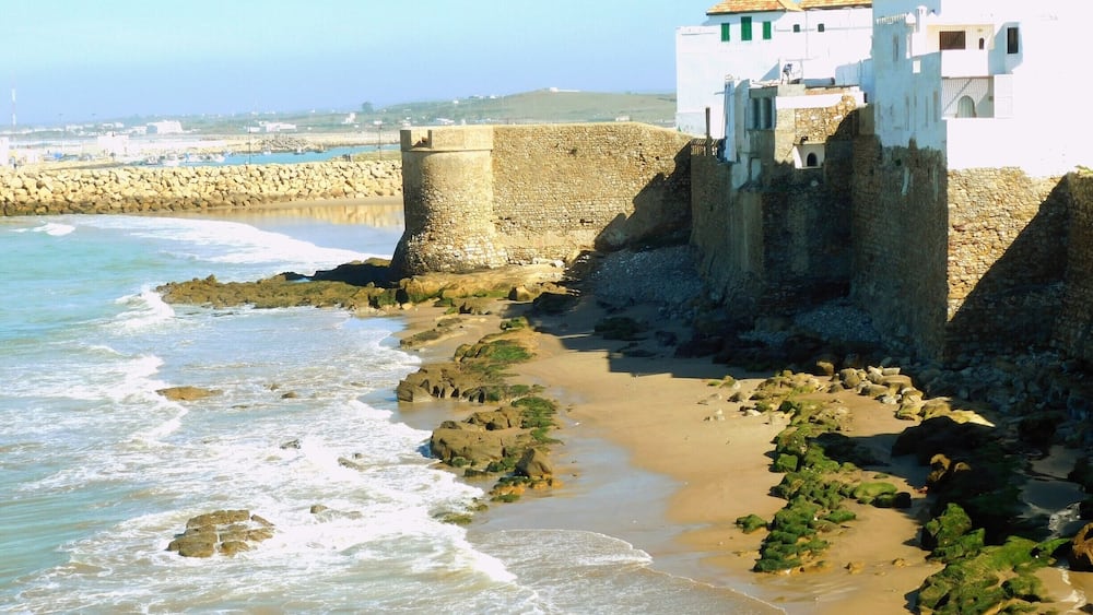 Asilah (Arabic: أصيلة، Aṣīla; Berber: ⴰⵥⵉⵍⴰ Aẓila; "authentic", Portuguese: Arzila, Spanish: Arcila) is a fortified town on the northwest tip of the Atlantic coast of Morocco, about 31 km (19 mi) south of Tangier. Its ramparts and gateworks remain fully intact.
The town's history dates back to 1500 B.C., when the Phoenicians used it as a base for trade. The Portuguese conquered the city in 1471, but later it was decided to abandon it because of an economic debt crisis in 1549. Later in 1578, Sebastian of Portugal used Asilah as a base town for his troops during a planned crusade that resulted in Sebastian's death, which in turn caused the Portuguese succession crisis of 1580. The Moroccans in 1589 regained control of Asilah briefly, but then lost control of it to the Spanish.
In 1692, the town was again taken by the Moroccans under the leadership of Moulay Ismail. Asilah served then as a base for pirates in the 19th and 20th centuries, and in 1829, the Austrians punitively bombarded the city due to Moroccan piracy.
From 1912 to 1956, it was part of Spanish Morocco. A major plan to restore the town was undertaken in 1978 by its mayor, Mohamed Benaissa. The first edition of an art festival known as the International Cultural Moussem of Asilah was launched that year to help generate tourism. It was successful in generating revenue for the city and played a role in raising the average monthly income from $50 in 1978 to $140 in 2014. The festival features local artwork and music and continues to attract large amounts of tourists.
Asilah is now a popular seaside resort, with modern holiday apartment complexes on the coast road leading to the town from Tangier.